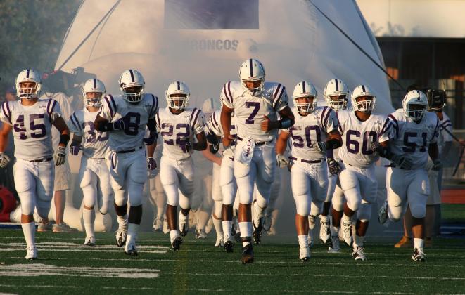 Cody Green leads the 2008 Dayton Broncos onto the field against Friendswood. Green along with the 2008 team will be honored as inductees to the Dayton Sports Hall of Fame this Saturday. Photo by Mike George Article Image Alt Text