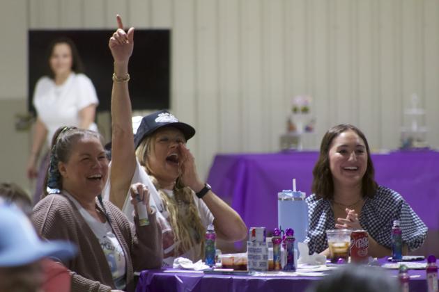 Misty Dehoyos (left), Beth Corbin and Addi Dehoyos cheer on emcee Jessi Parham (not pictured) as Parham makes jokes during the Third Annual Making Memories for Myles Bingo Night. Article Image Alt Text
