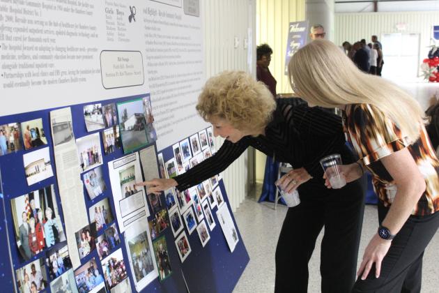 Chambers County Public Hospital District No. 1 Director Annette Abernathy (left) shows a photo to Holly Mitchell, registered nurse. Article Image Alt Text