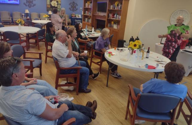 For the Chambers County Library System’s summer reading program, on June 12, Jim Castro (far right) with Frascone Winery explains the intricacies of winemaking while dressed as a grape cluster. Participants enjoy four samples from Frascone and two of Castro’s specialty wine-infused coffees. Article Image Alt Text