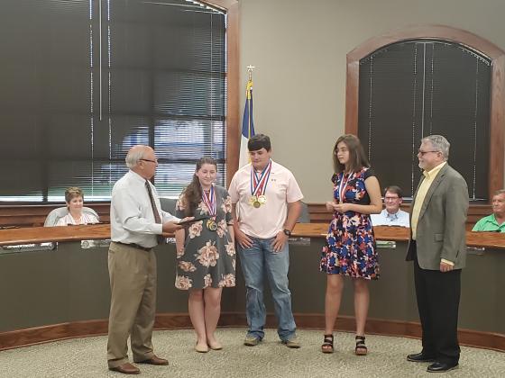 Members of the LHS State Champion Literary Criticism team are presented with a proclamation from Liberty Mayor Carl Pickett. Article Image Alt Text