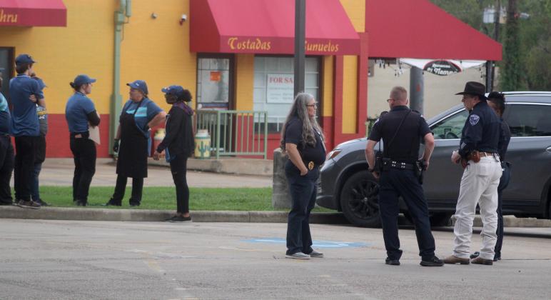 Liberty Police work the scene of a bomb threat at Sonic while employees stand outside the building. Article Image Alt Text