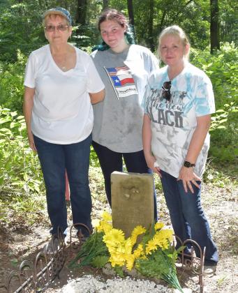 Linda McNeil, Aspyn McNeil, and Christi Fitch at the newly cleaned-up gravesite of Annie McShan. Photo by James Hefley Article Image Alt Text