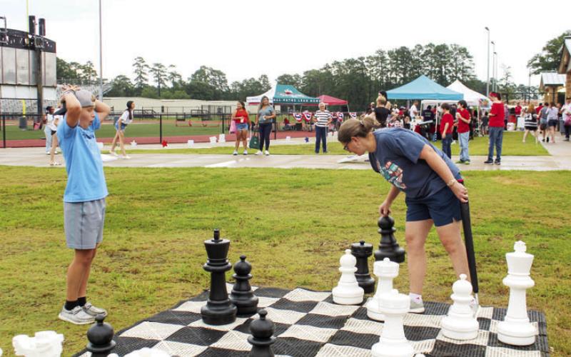 Kathy Sweger (right) makes an impressive chess move as her son, Henry Sweger, expresses shock at Cleveland’s Independence Day celebration at Indian Stadium. Photo by Celeste Denova