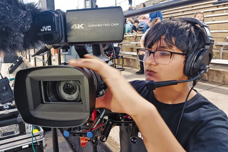 Liberty High School junior Jose Becerra sets up a camera for a Panther Sportz Network broadcast of a football game. Contributed Photo