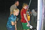 Isaac Block (back left) looks at moths and other insects with his sons, Patrick (front left) and Thomas Block at the Trinity River National Wildlife Refuge’s annual Moth Night Out. Photo by Celeste Denova